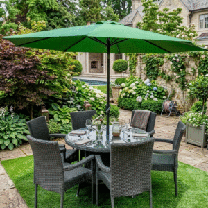 Round 6-seater grey rattan dining set with a large green patio umbrella, set for brunch on a stone patio with lush garden greenery and white hydrangeas.